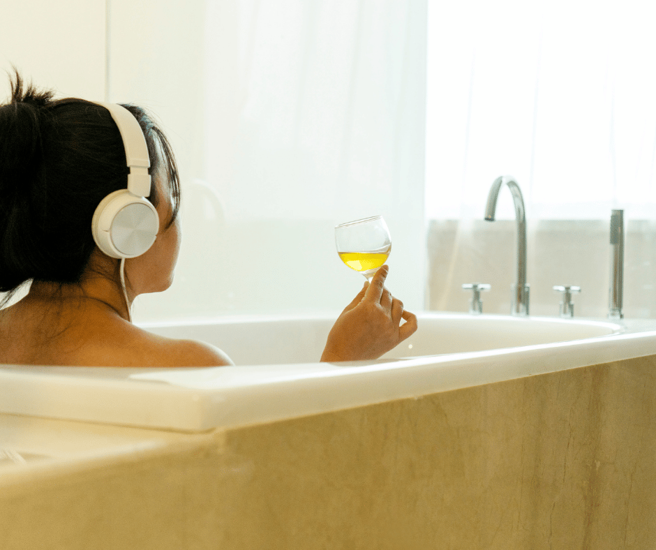 Frau in Badewanne mit Glas Wein