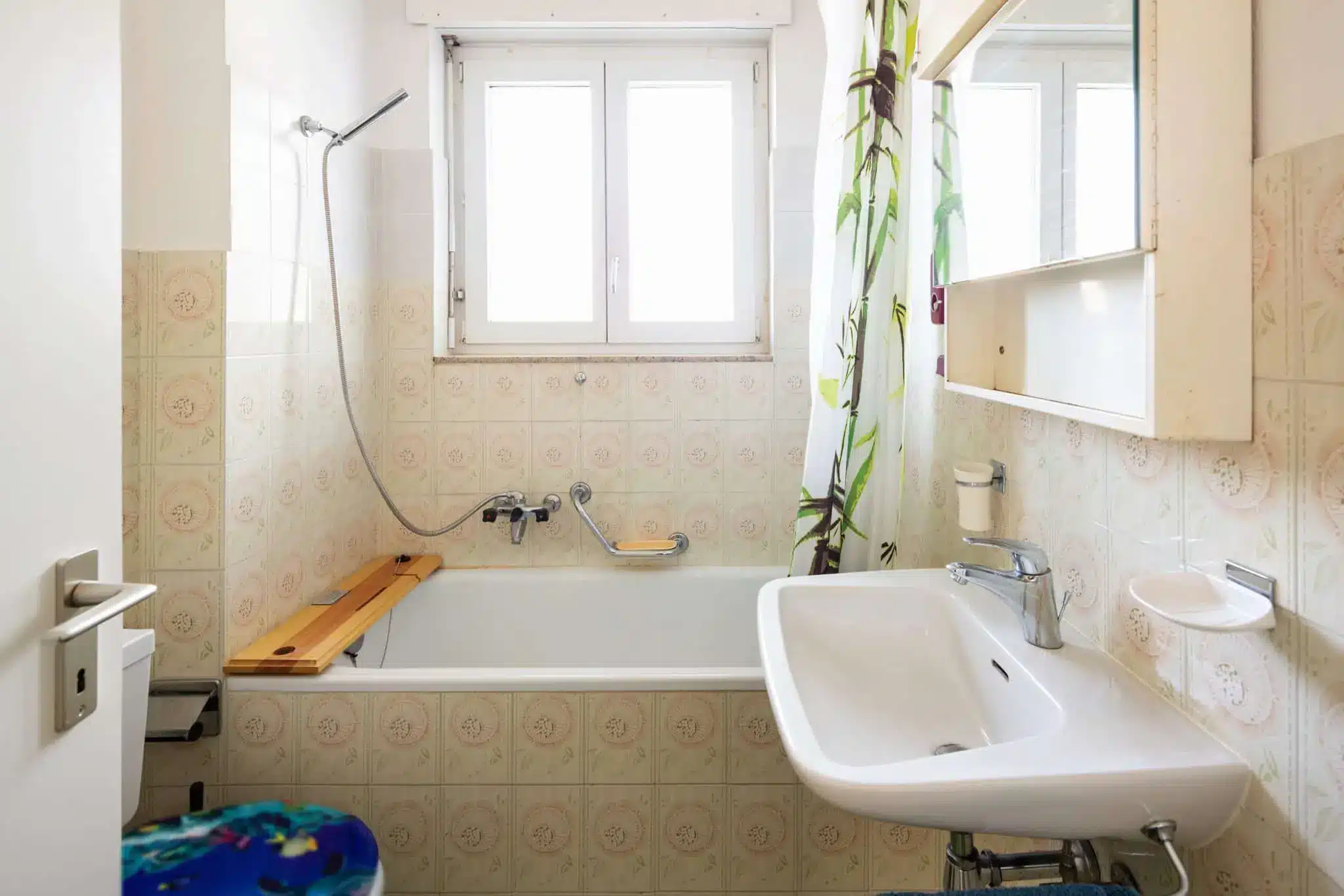 Vintage bathroom with green tiles and window
