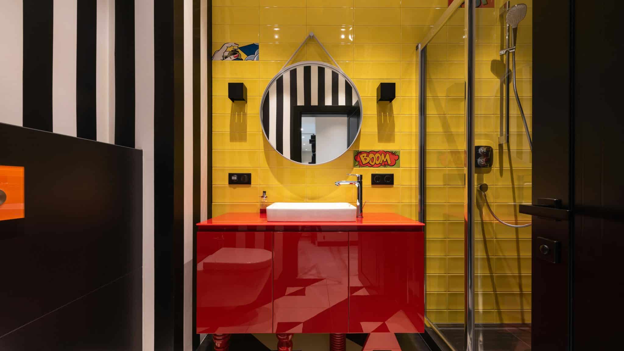 Buntes Badezimmer mit gelber Wand und rotem Waschbecken