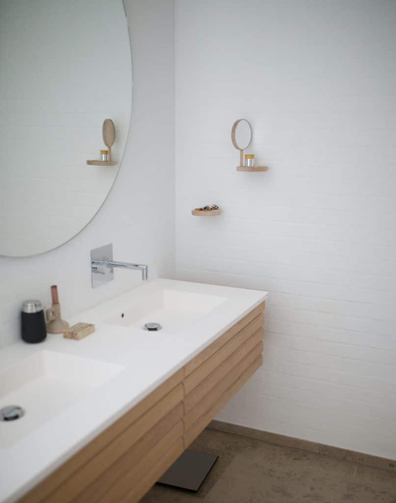 Doppelwaschbecken mit Unterschrank aus Holz und rundem Spiegel
